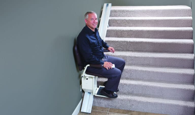 happy man sitting on safe step stair lift